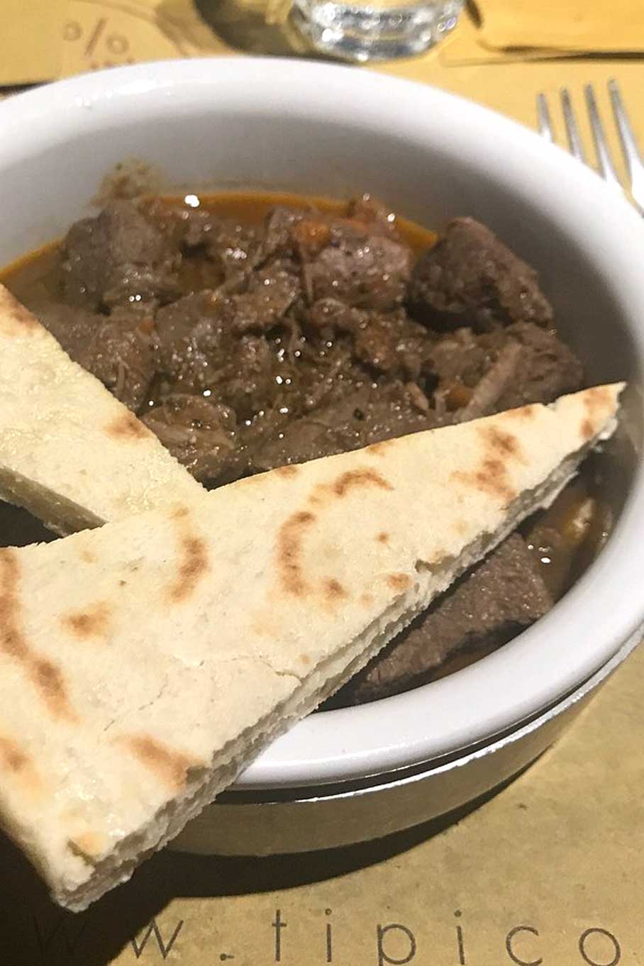 Tegamaccio di Cinghiale con torta al testo di grani antichi menu Tipico Osteria Montone