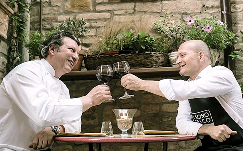 Lo chef Giancarlo Polito e l'oste Paolo Morbidoni brindano fuori dell'Osteria Tipico a Montone