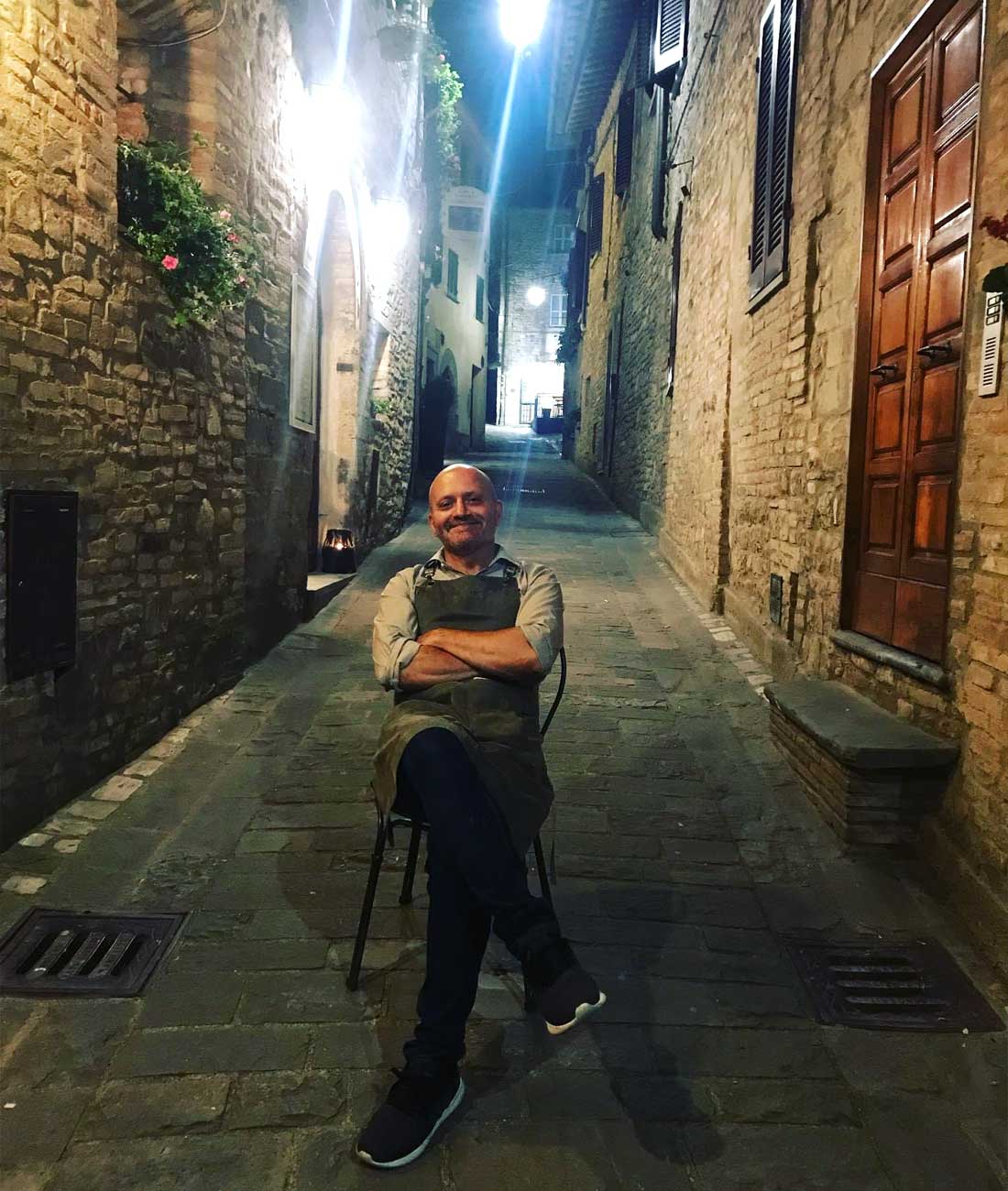 Paolo Morbidoni seduto fuori dal suo ristorante nel cuore del borgo di Montone in Umbria