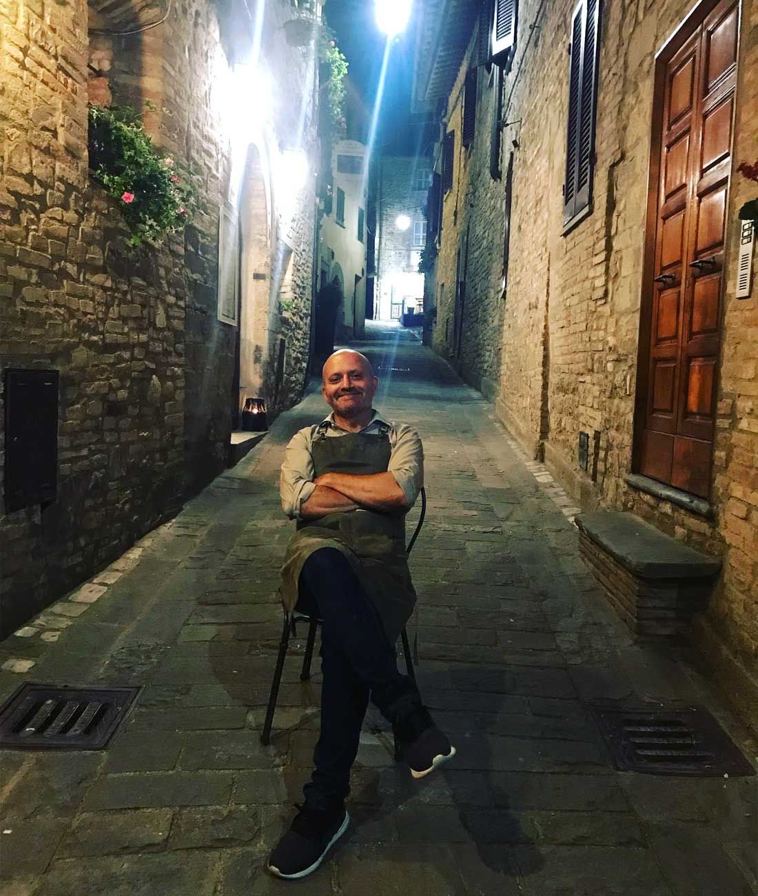 Paolo Morbidoni seduto fuori dal suo ristorante nel cuore del borgo di Montone in Umbria 